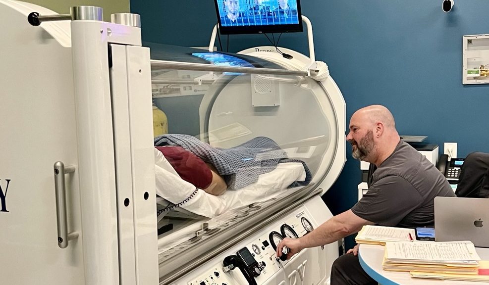 HBOT tech with a Parkinson's patient receiving HBOT to help with her condition.